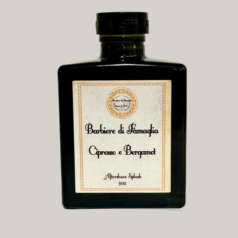 A black glass jar with a label that reads 'Barbiere di Famiglia' and 'Cipresso e Bergamot' indicating an aftershave splash with cypress and bergamot scents.